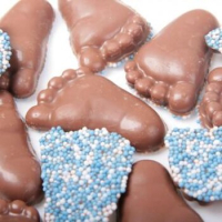 12 chocolade babyvoetjes met musket in roze of blauw